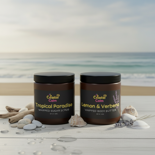 Two jars of Coastal Calm body products on a beach setting with ocean in the background.