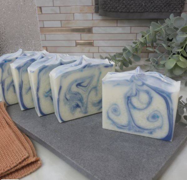 Clean Cotton Soap Bar - Pure & Refreshing with blue and white swirls, handcrafted for soft, smooth skin. Displayed on a slate tray in a spa setting.