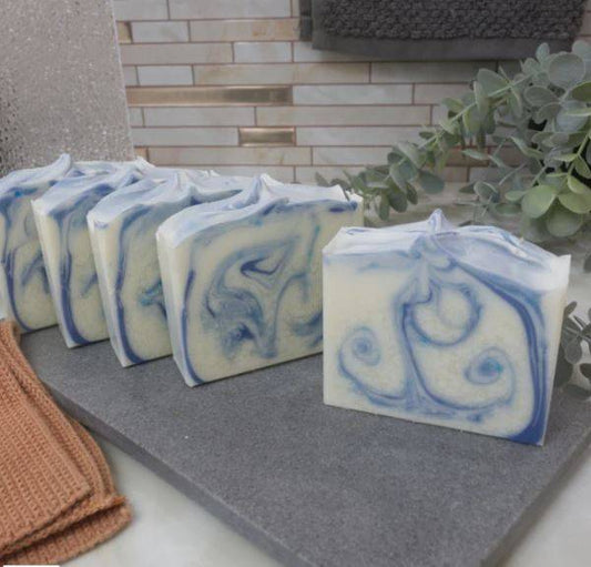 Clean Cotton Soap Bar - Pure & Refreshing with blue and white swirls, handcrafted for soft, smooth skin. Displayed on a slate tray in a spa setting.