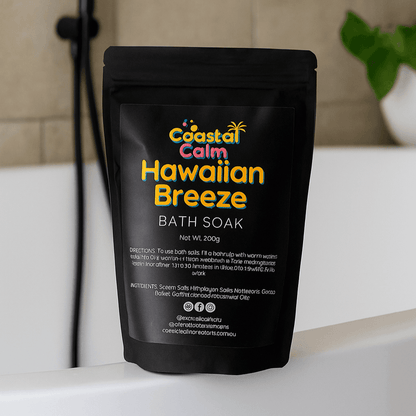 Coastal Calm Hawaiian Breeze Bath Soak package on a bathtub with a tiled wall background